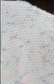 Pink Purple Green: Close-up of textured fabric with multicolor speckles on a dark background